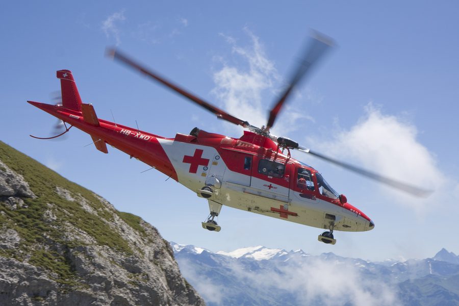 An Agusta A109 in flight over mountains